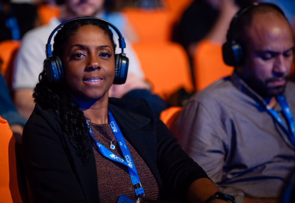Participantes en el público siguiendo la charla con auriculares