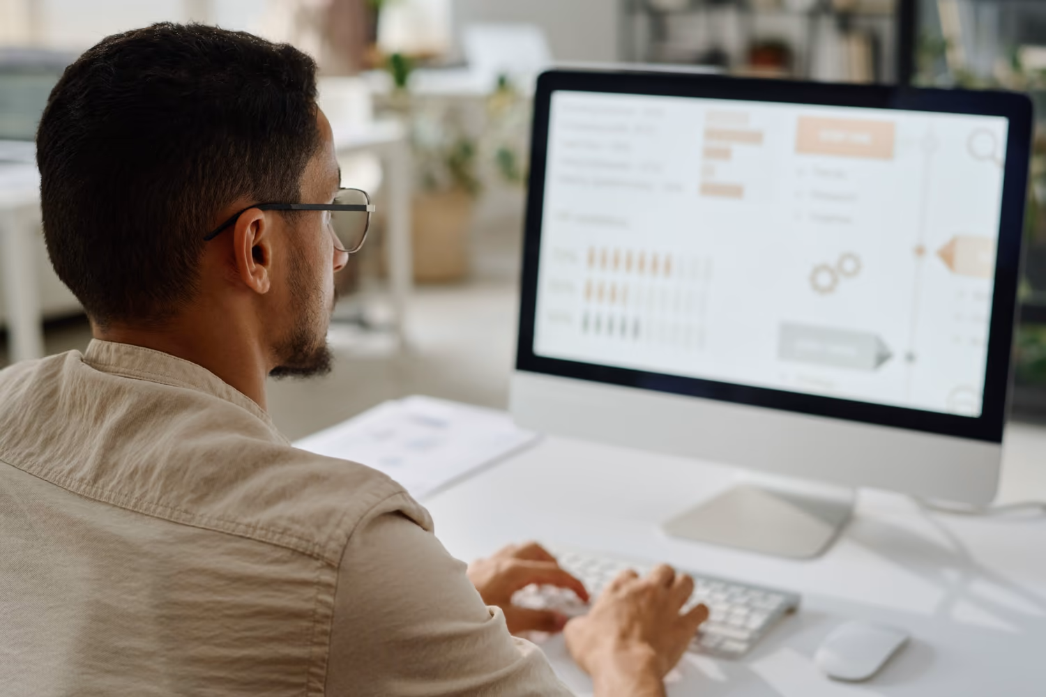 Profesional analizando datos en la pantalla de una computadora, con gráficos e indicadores, en un entorno moderno. Está enfocado en procesos relacionados con MDM (Master Data Management), un área esencial para la optimización y governanza de datos, como las soluciones ofrecidas por 4MDG.